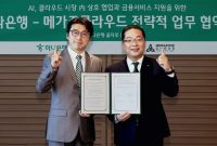 Max Lee (left), Chairman of MegazoneCloud, and Hosung Lee, CEO of Hana Bank, pose for a photo following the signing of a strategic business cooperation agreement in the AI cloud market and expanded support for financial services.